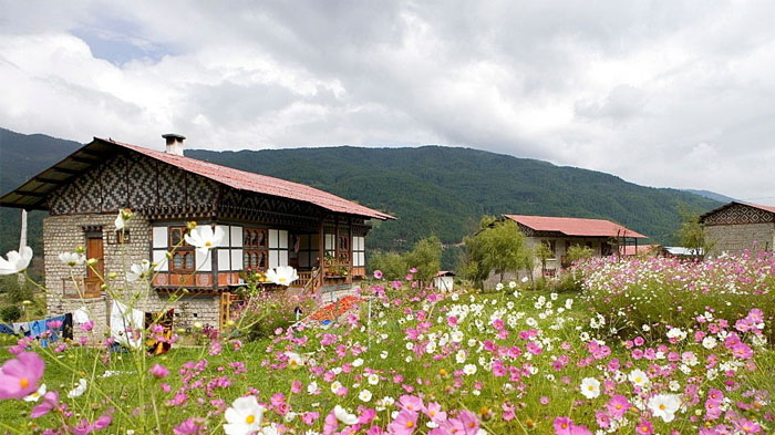 Characteristic Bhutan village surrounded by lush flowers in May