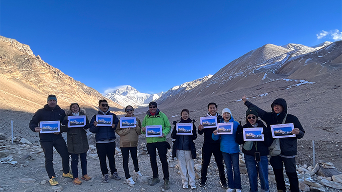 takes pictures in front of Mount Everest