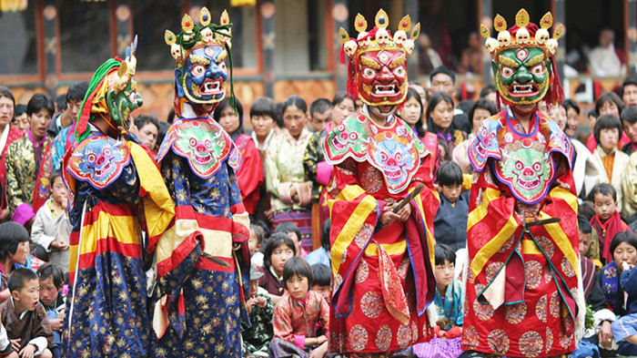 Lamas in colorful dresses and masks during Punakha Drubchen Festival