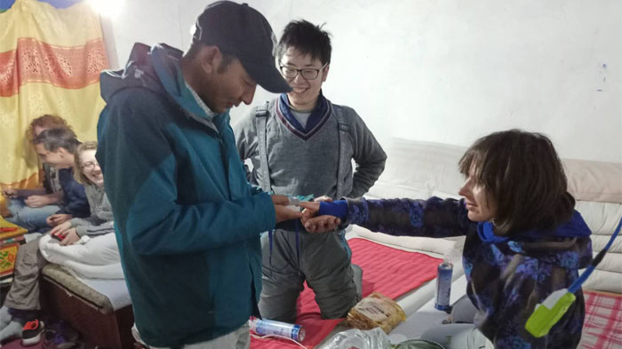 Tibetan guide checks our client oxygen level with the pulse oximeter