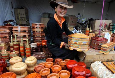 A local Tibetan girl is selling hand-made wood-ware.