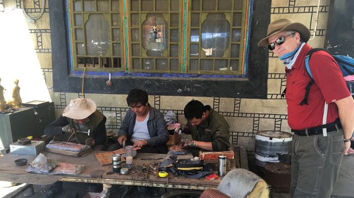 Tibetan artisans making bronze Buddha statues in the open air