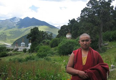 A monk is greeting new visitors before Reting Monastery