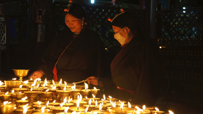 Local Tibetan pilgrims light Butter Lamp