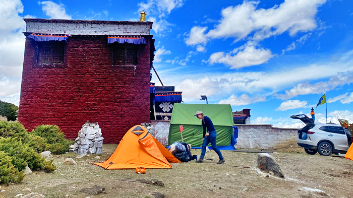 Pitch tent beside a serene Tibetan monastery on the Namtso Lake trek