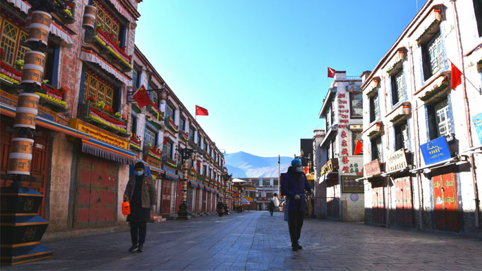 The empty Barkhor Street with only staff sanitizing the street