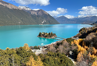 Basumtso lake, cradled by snow-capped peaks and lush forests