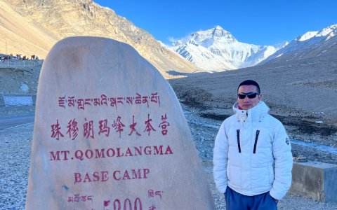 Traveler photo: Beside the Everest Base Camp monument, a guest faces the camera as the 8,848-meter peak stands silently behind. (April 2026)