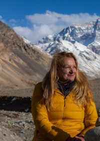 Traveler photo: A guest poses at Everest Base Camp with the towering, crystal-clear peak behind them—the world's rooftop in full view. (April 2026)
