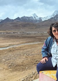 Traveler photo: A guest sits by the roadside, quietly taking in the distant snow-capped mountains, savoring a moment of plateau peace. (April 2026)