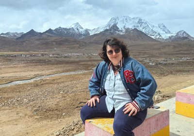 Traveler photo: A guest sits by the roadside, quietly taking in the distant snow-capped mountains, savoring a moment of plateau peace. (April 2026)