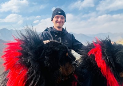 Traveler photo: With arms gently around the mastiffs, the lens captures a moment of quiet trust between human and animal. (April 2026)