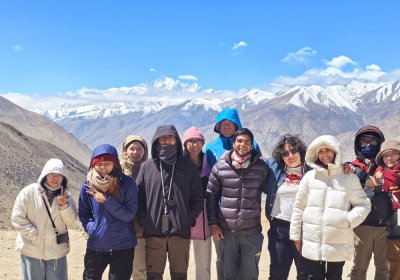Traveler photo:  Guests chat and laugh at Gawula Pass, with the rolling Himalayan snow mountains behind them.  (April 2026)