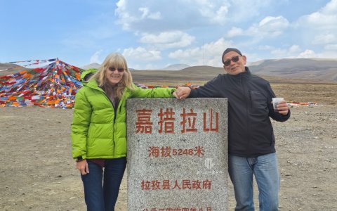 Traveler photo: Two guests stand side by side at the Gyatsola Pass monument, capturing a precious photo from their plateau journey. (April 2026)