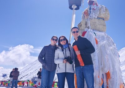 Traveler photo: A loving family huddles together for a warm photo in front of the Karola Glacier. (April 2026)