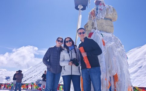 Traveler photo: A loving family huddles together for a warm photo in front of the Karola Glacier. (April 2026)