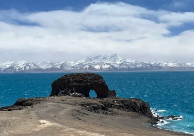 Traveler photo: By turquoise Namtso Lake, a natural stone gate stands silently—where blue waters and grey rocks speak in plateau stillness. (April 2026)