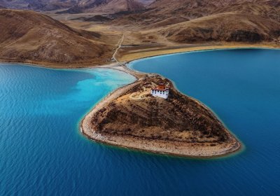 Traveler photo: From above, Rituo Temple sits alone on turquoise Yamdrok Lake—a solitary island cut off from the world. (April 2026)