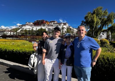 Traveler photo: A family smiles together before the Potala Palace, capturing a warm group photo with the grand building behind them. (August 2026)