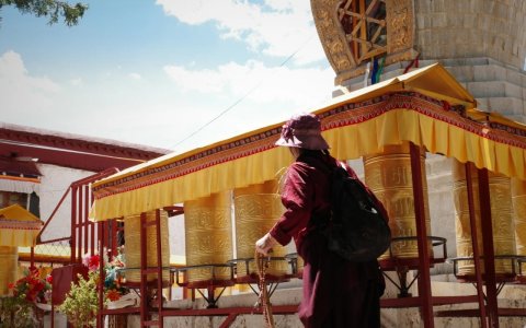 Traveler photo: A local Tibetan spins a large prayer wheel inside a monastery. (August 2026)