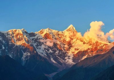 Traveler photo: The setting sun paints the snowy summit of Mount Namcha Barwa in gold, softening its ridges as dusk settles. (August 2026)