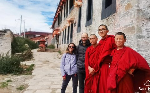 Traveler photo: Guests posing with Tibetan monks dressed in their traditional red robes. (August 2025)