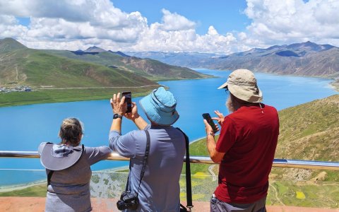 Traveler photo: Our travelers take photos along the shore of Yamdrok Lake. (August 2026)