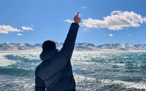 Traveler photo: By Namtso Lake, the guest stands alone gazing into the distance, their silhouette blending into the holy lake and snow mountain panorama. (December 2025)