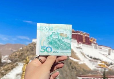 Traveler photo: Before Potala Palace in Lhasa, a traveler holds up a fifty-yuan bill to match the actual scene with its printed image. (December 2025)