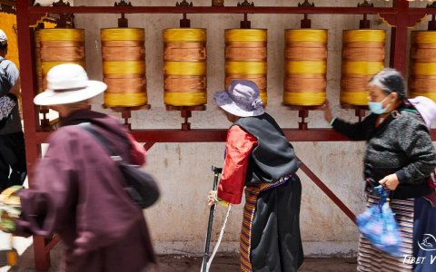 Traveler photo: Before bronze prayer wheels in Lhasa, we documented the moment a local devotee rotates scriptures while silently reciting mantras. (December 2025)