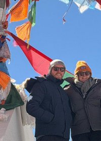 Traveler photo: At a mountain pass in Tibet, our guests are gently surrounded by colorful prayer flags, each breeze carrying millennia of blessings. (February 2026)
