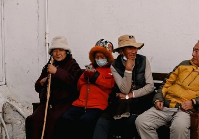 Traveler photo: On benches along Barkhor Street in Lhasa, Tibet, several locals sit enjoying leisurely afternoon moments. (February 2026)