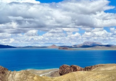 Traveler photo: Under blue skies and white clouds, Yamdrok Lake gleams a brilliant blue, like a gem set among the mountains. (July 2026)