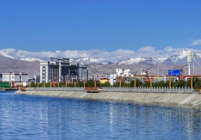 Traveler photo: A river runs through the Tibetan city, flanked by neat Tibetan houses and broad streets—where urban life meets nature. (July 2026)