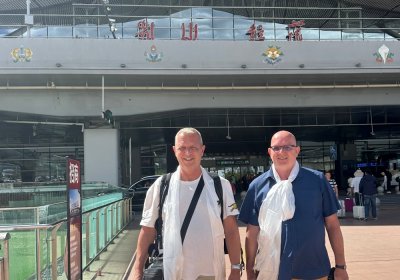 Traveler photo: A candid shot of two guests just off the plane, relaxed and smiling with luggage in hand. (July 2026)