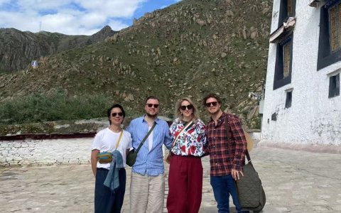 Traveler photo: After the visit, guests gather for a group photo in front of the temple, framed by ancient Tibetan architecture. (July 2026)