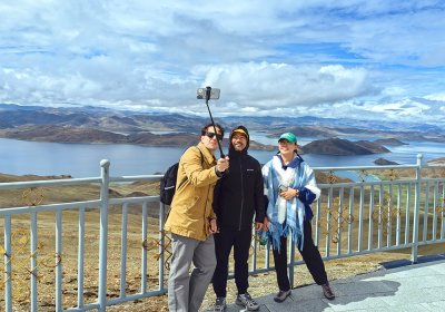 Traveler photo: Our guests explore the Kampala pass, framed by the blue water of Yamdrok lake. (July 2026)	