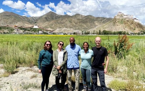 Traveler photo: In July, enjoy a distant view of Tashilhunpo Monastery set against a backdrop of blooming oilseed flowers. (July 2025)