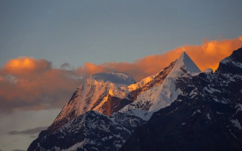 Traveler photo: The sunset bathes Tibet's snow mountains in warm gold, while the peaks slowly darken into dusk. (July 2026)