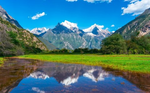 Traveler photo: Summer in Tibet brings reflections of snowy peaks on still sacred lakes, mirroring the surrounding landscape. (July 2026)