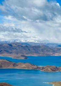 Traveler photo: Tibet's Yamdrok Lake shimmers in layered blues, a turquoise ribbon winding through majestic mountains. (June 2026)