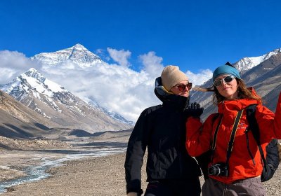 Traveler photo: Couple smiling in front of Mount Everest at the Base Camp, framed by the clear view of the world's highest peak. (June 2026)	