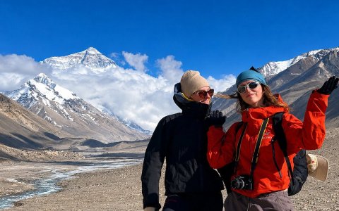 Traveler photo: Couple smiling in front of Mount Everest at the Base Camp, framed by the clear view of the world's highest peak. (June 2026)	