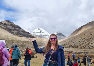 Traveler photo: Playfully “holding” the sacred peak at its base, the guest frames Mount Kailash together with a smile. (June 2026)