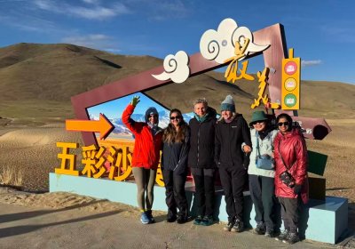 Traveler photo: Our guests stand together in a Tibetan desert, capturing a joyful group photo between blue sky and golden sand. (June 2026)