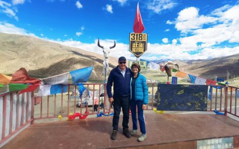 Traveler photo: Two guests share a loving smile at the mountain pass monument, capturing a heartwarming photo together. (June 2026)