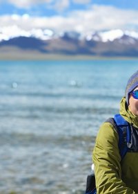 Traveler photo: By the shore of Namtso Lake, guests lean back as distant snowy mountains and blue lake water fill the frame. (June 2026)