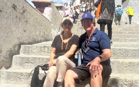 Traveler photo: Guests sit on the palace stairs, taking a break and looking up at the ancient building. (June 2026)