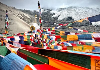 Traveler photo: The icy solemnity of Karola Glacier contrasts with vivid prayer flags—a uniquely sacred Tibetan view. (June 2026)