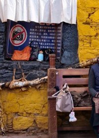 Traveler photo: Elderly women sit serenely by Lhasa's vibrant walls, basking in the sunlight. (Jun 2025)